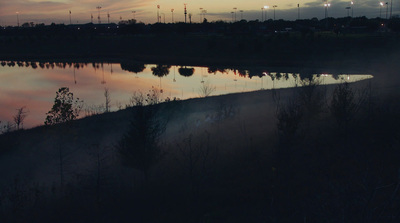 a body of water surrounded by trees and lights