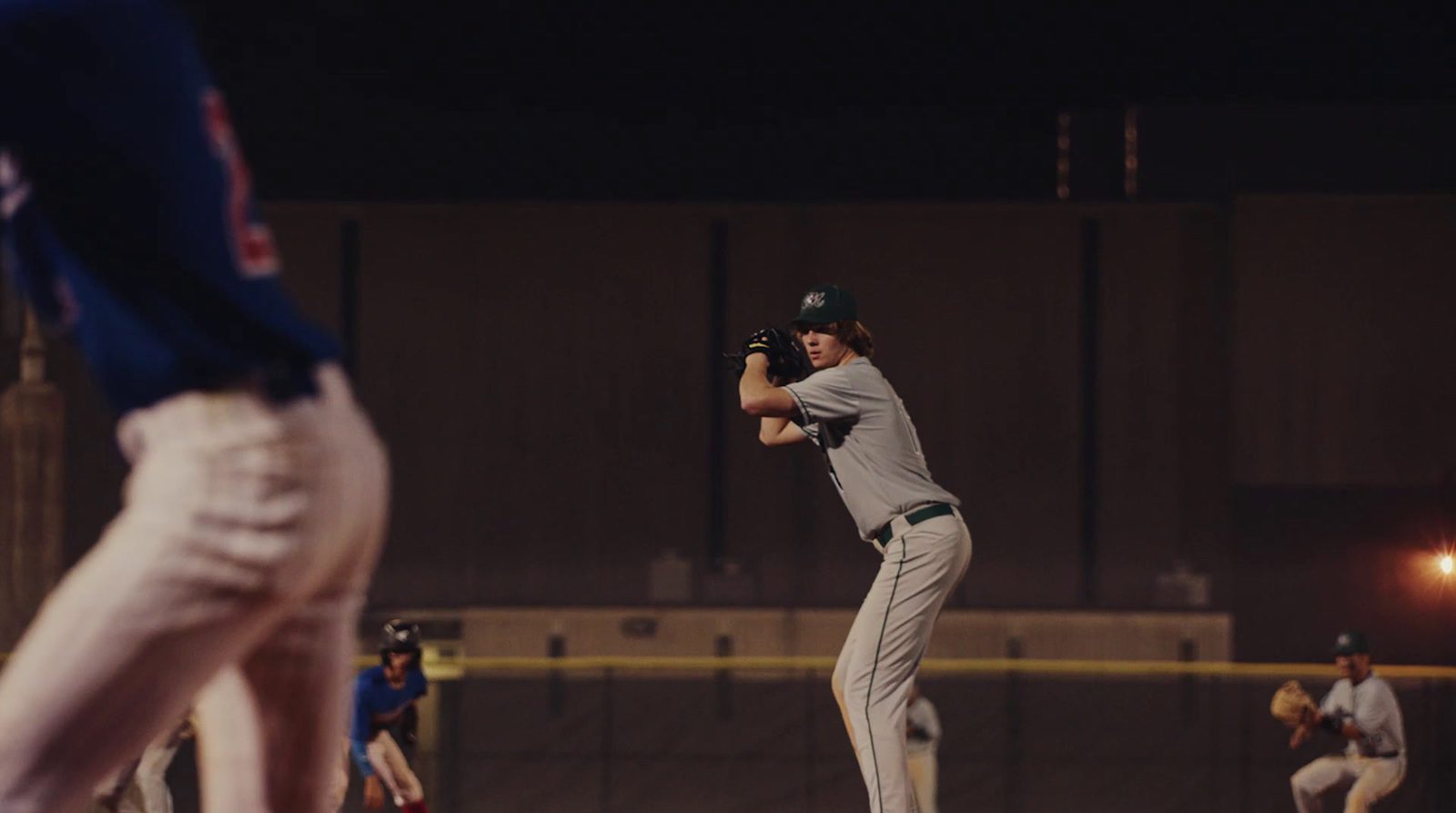 a baseball player pitching a ball on top of a field