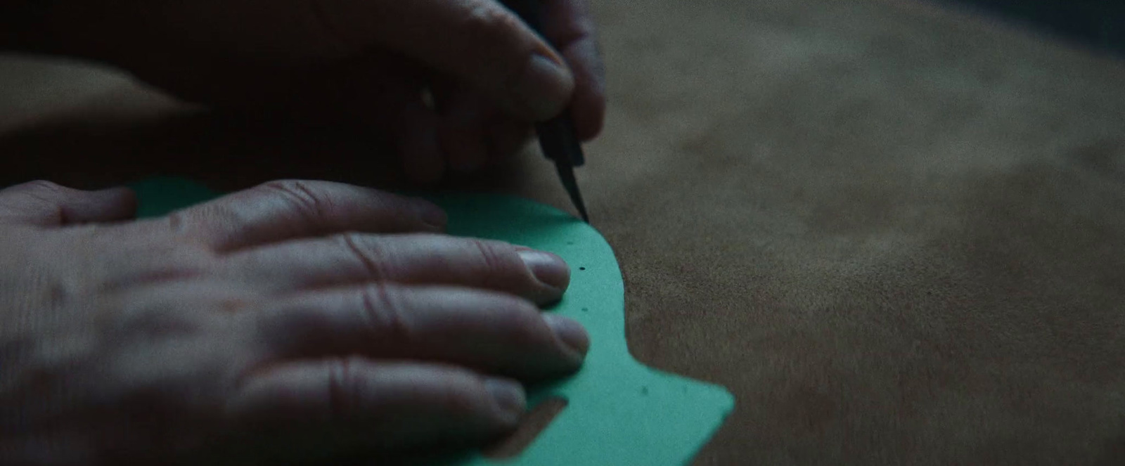 a person cutting a piece of paper with a pair of scissors