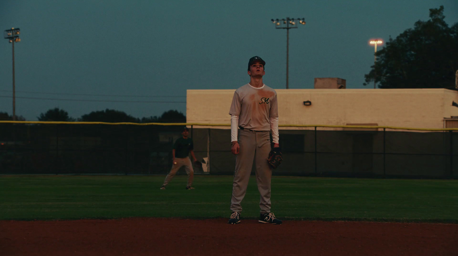 a man standing on a baseball field holding a catchers mitt