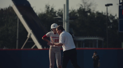 a couple of people that are standing on a baseball field