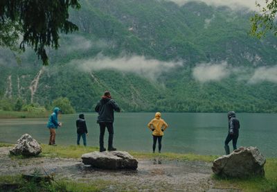 a group of people standing on top of a lush green hillside