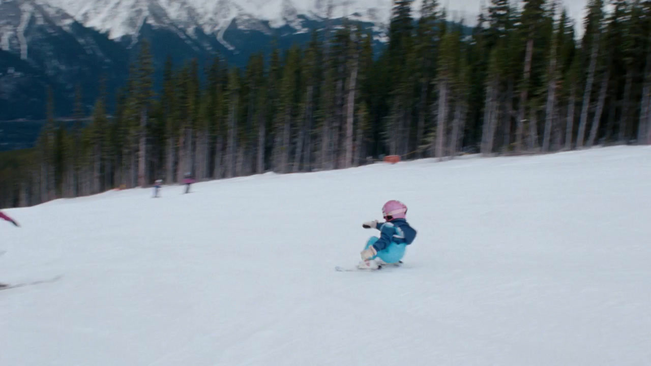 a group of people riding skis down a snow covered slope