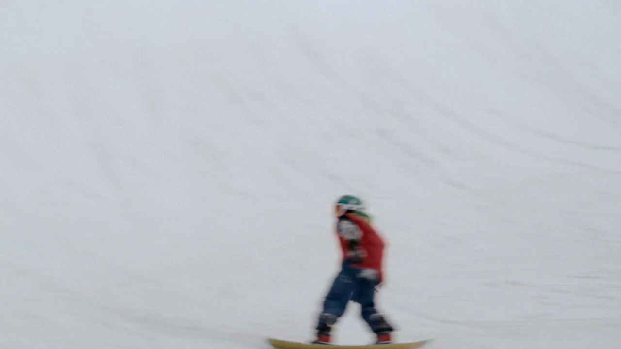 a man riding a snowboard down a snow covered slope