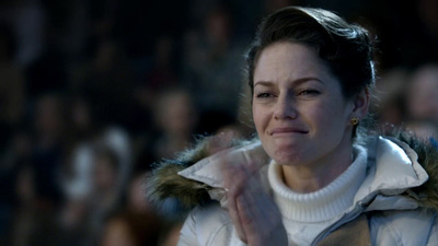 a woman in a white sweater is clapping