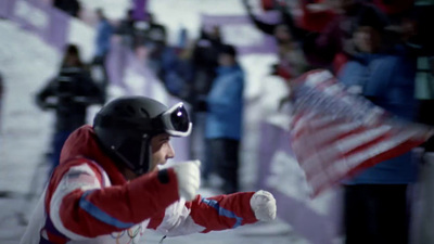 a man in a red and white jacket holding an american flag