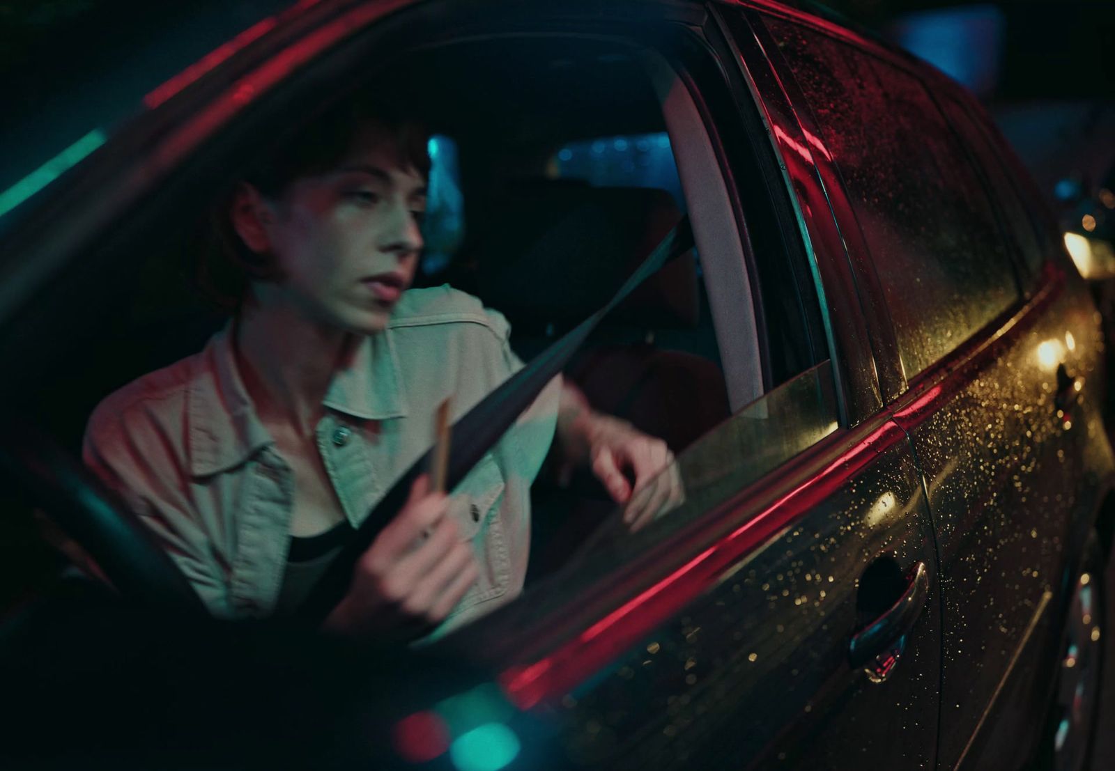 a woman sitting in a car with a knife in her hand