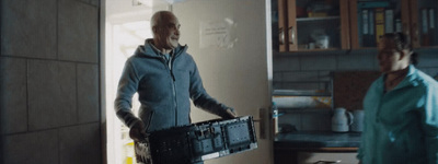 a man holding a box in a kitchen