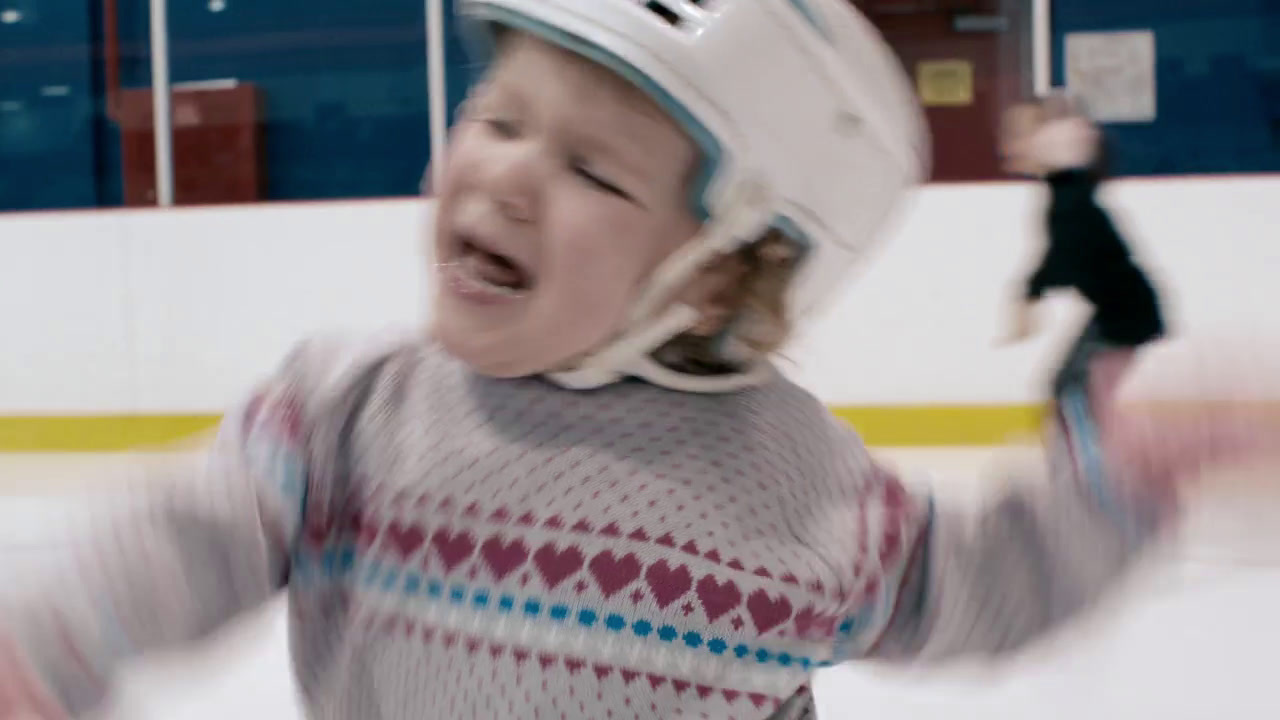 a young girl wearing a hockey helmet and holding a hockey stick