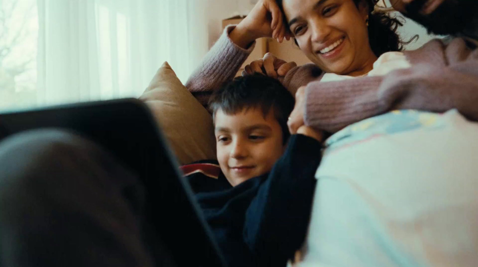 a woman and a boy laying on a bed