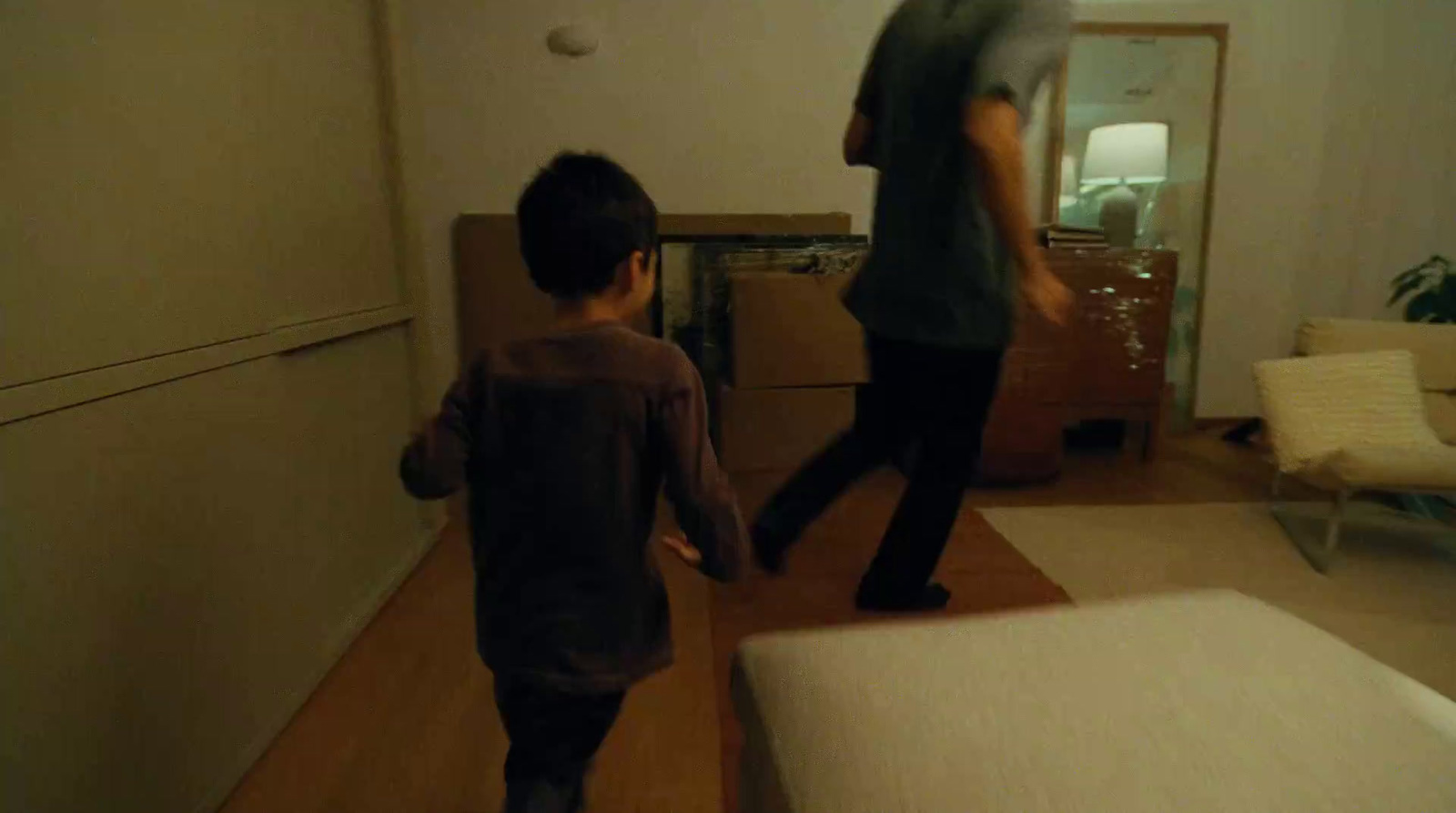 a man and a child are walking in a room