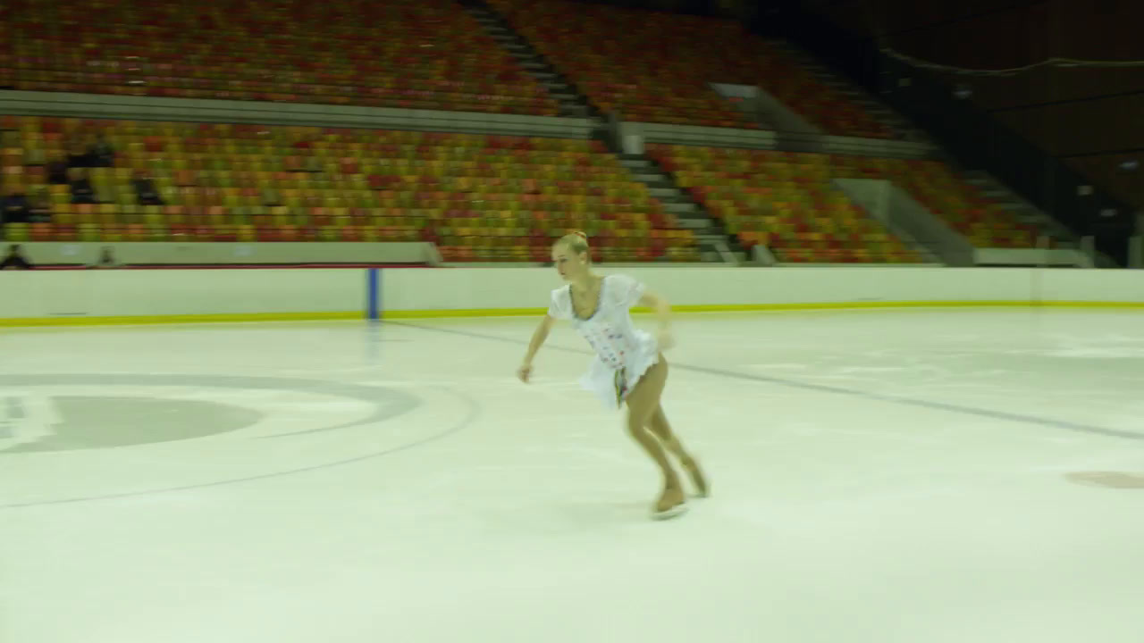 a female figure skating on an ice rink