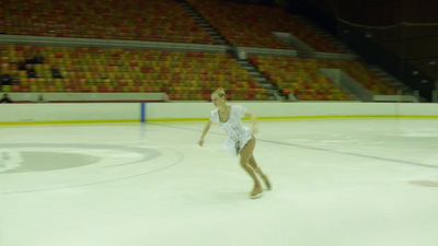 a female figure skating on an ice rink