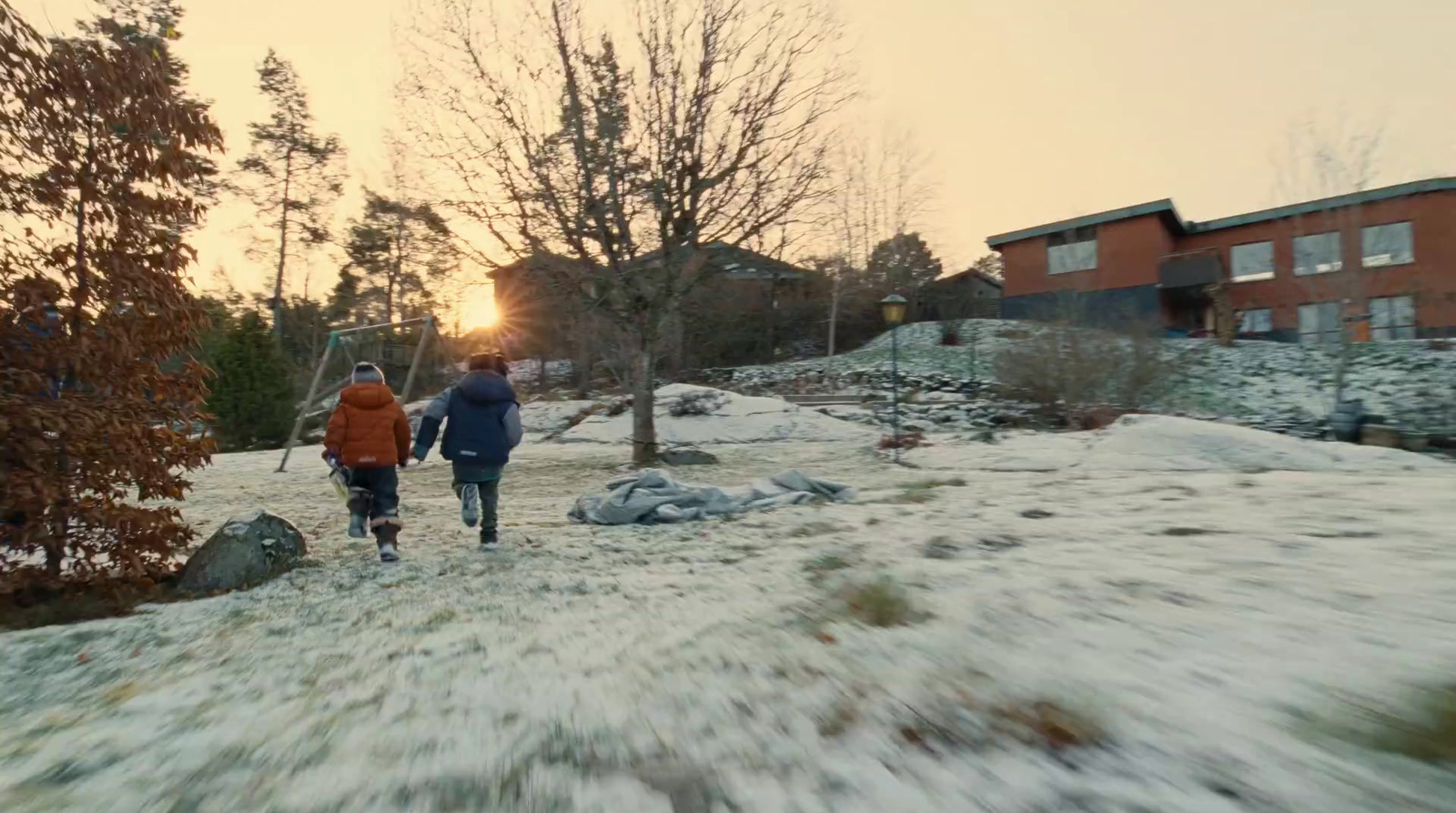 a couple of people walking across a snow covered field