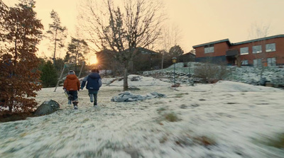 a couple of people walking across a snow covered field