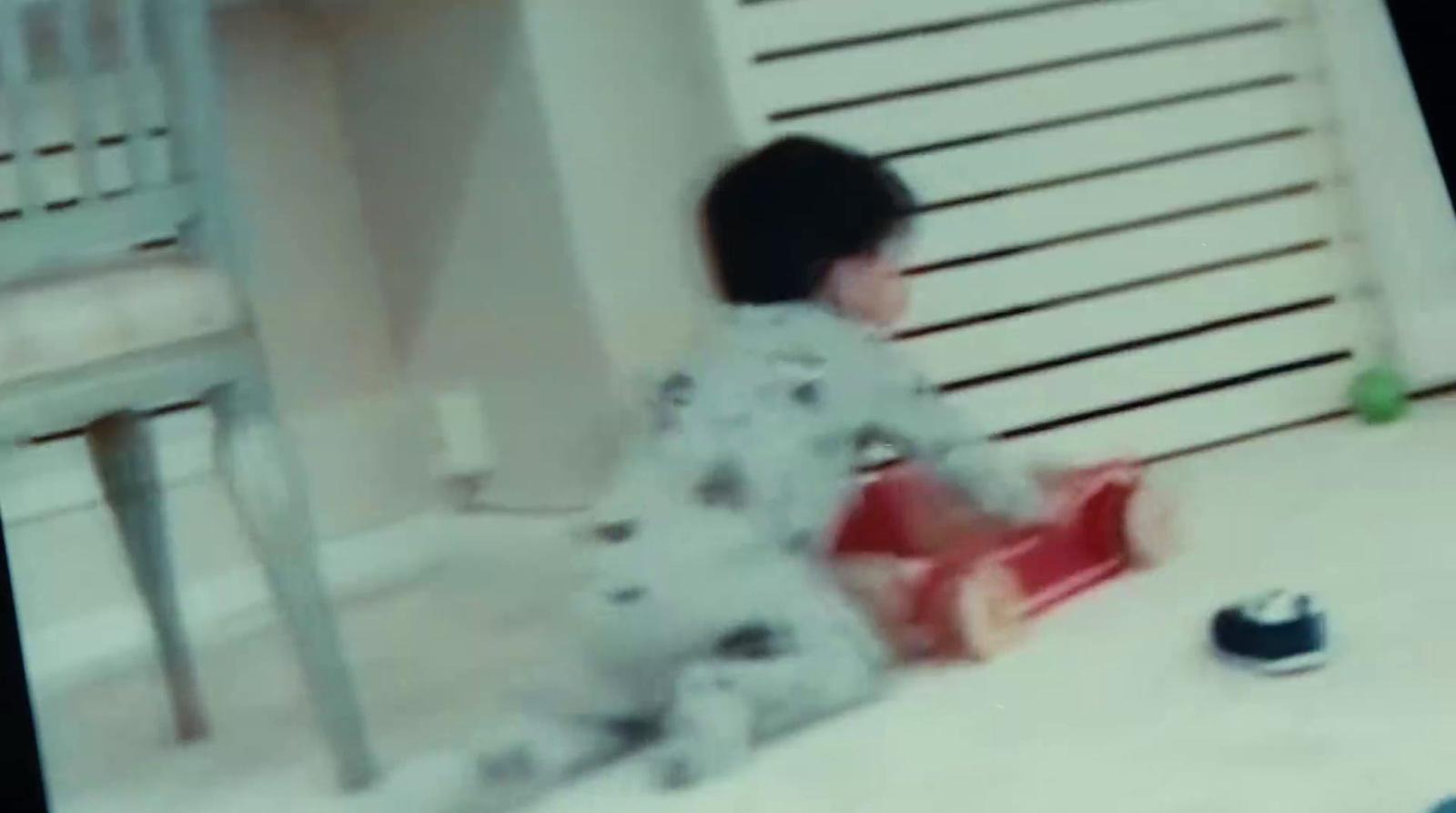 a young boy sitting on the floor playing with a toy