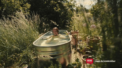 a person in a bathtub surrounded by tall grass