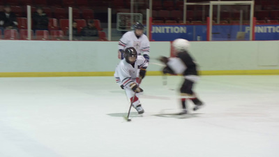 a couple of people playing a game of ice hockey