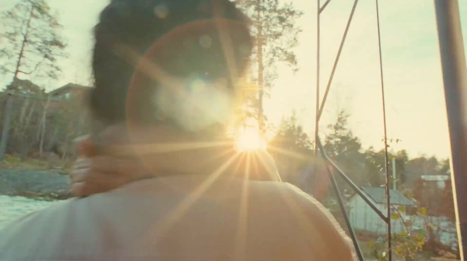 a man standing on a bridge with the sun shining behind him