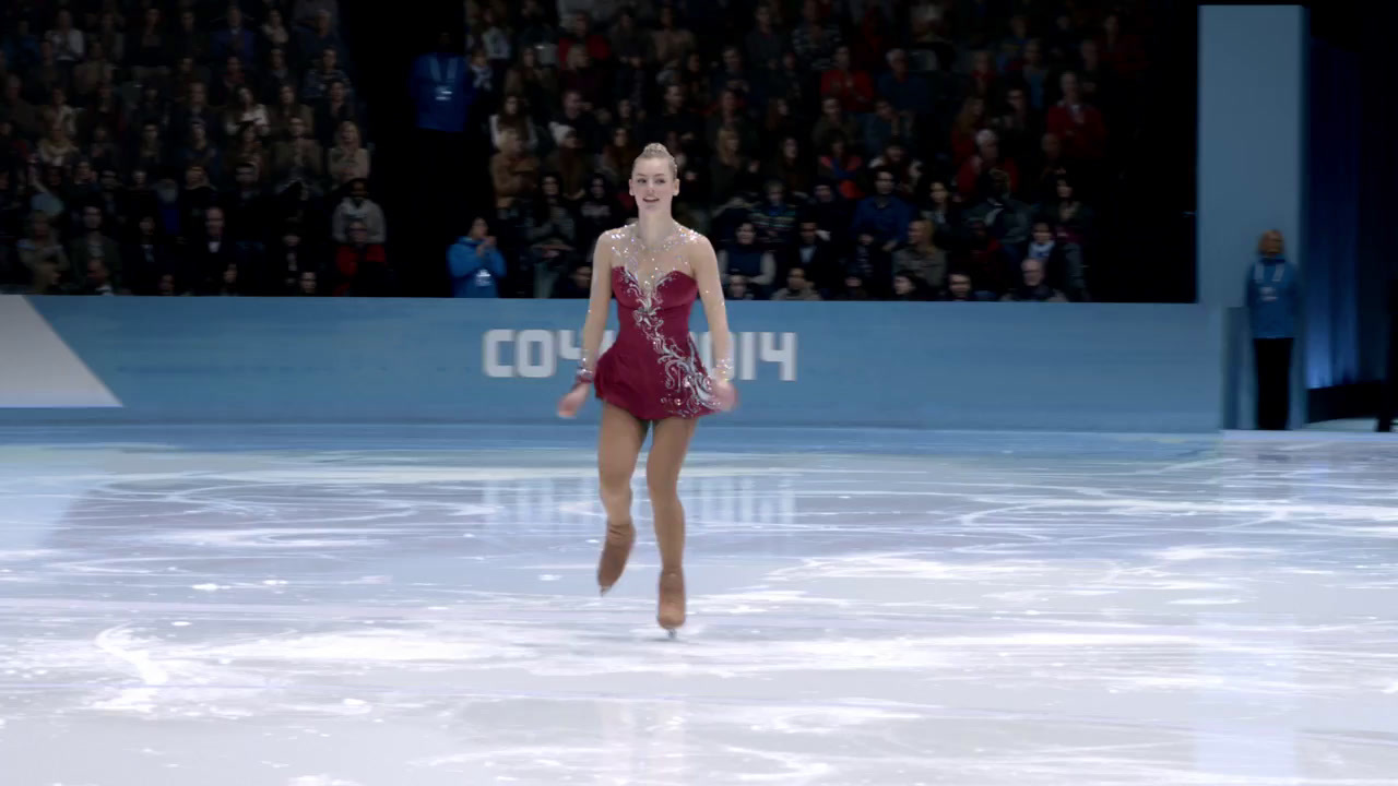 a woman in a red dress skating on a rink