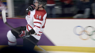 a man in a red and white uniform holding a hockey stick