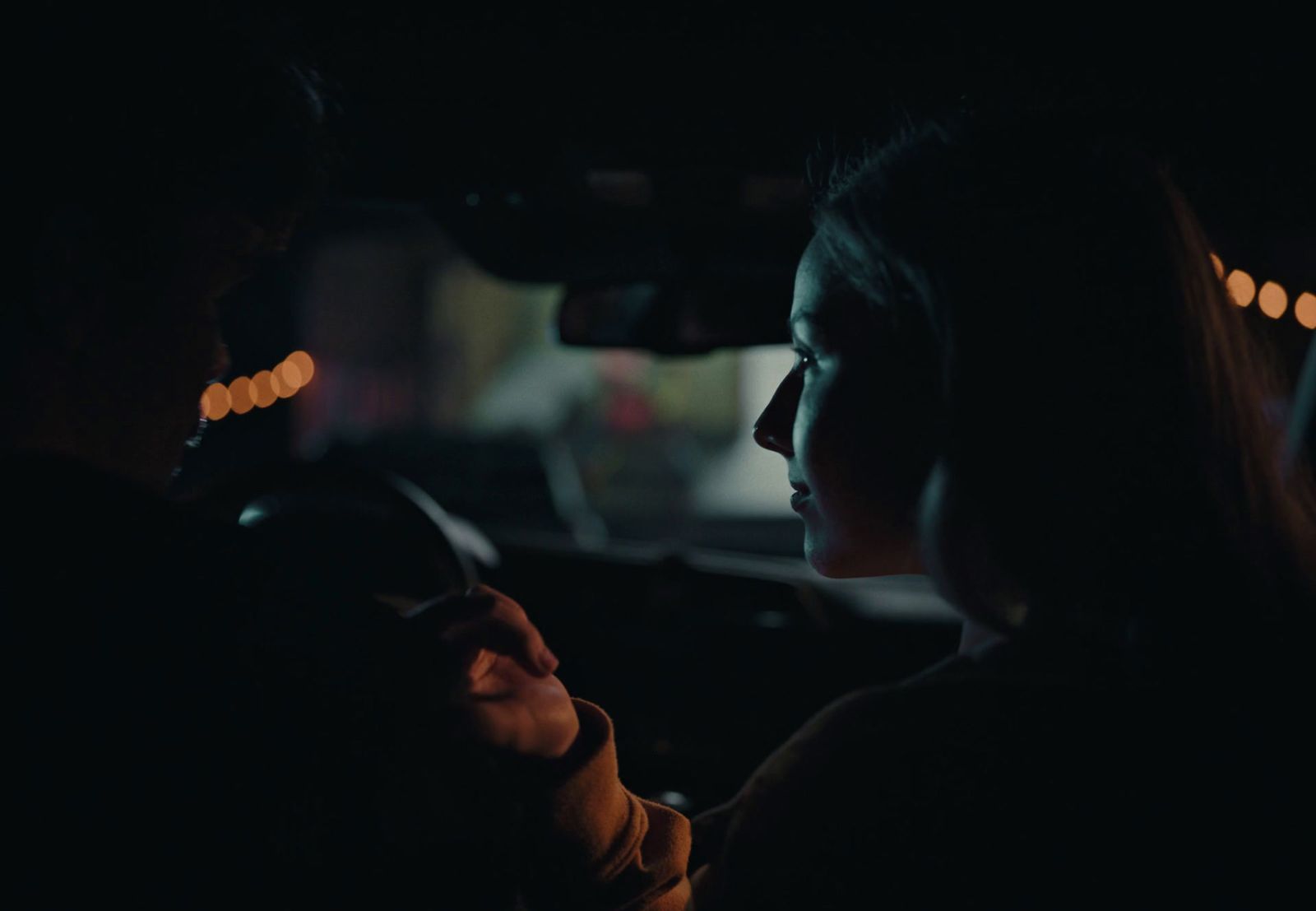 a woman driving a car in the dark