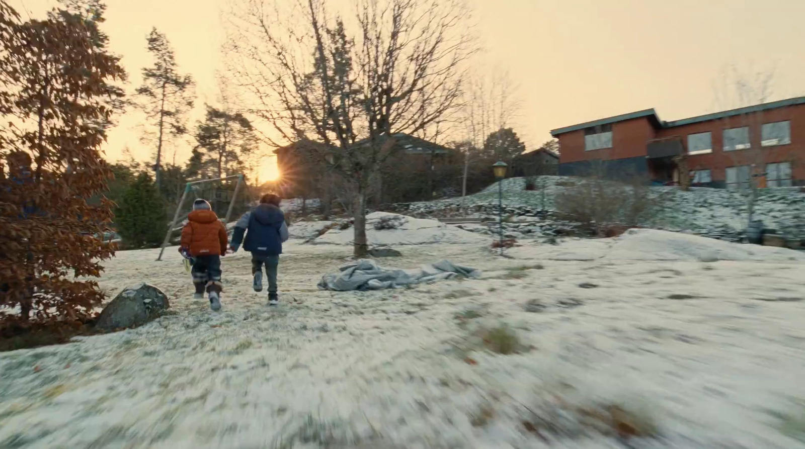 a couple of people walking across a snow covered field