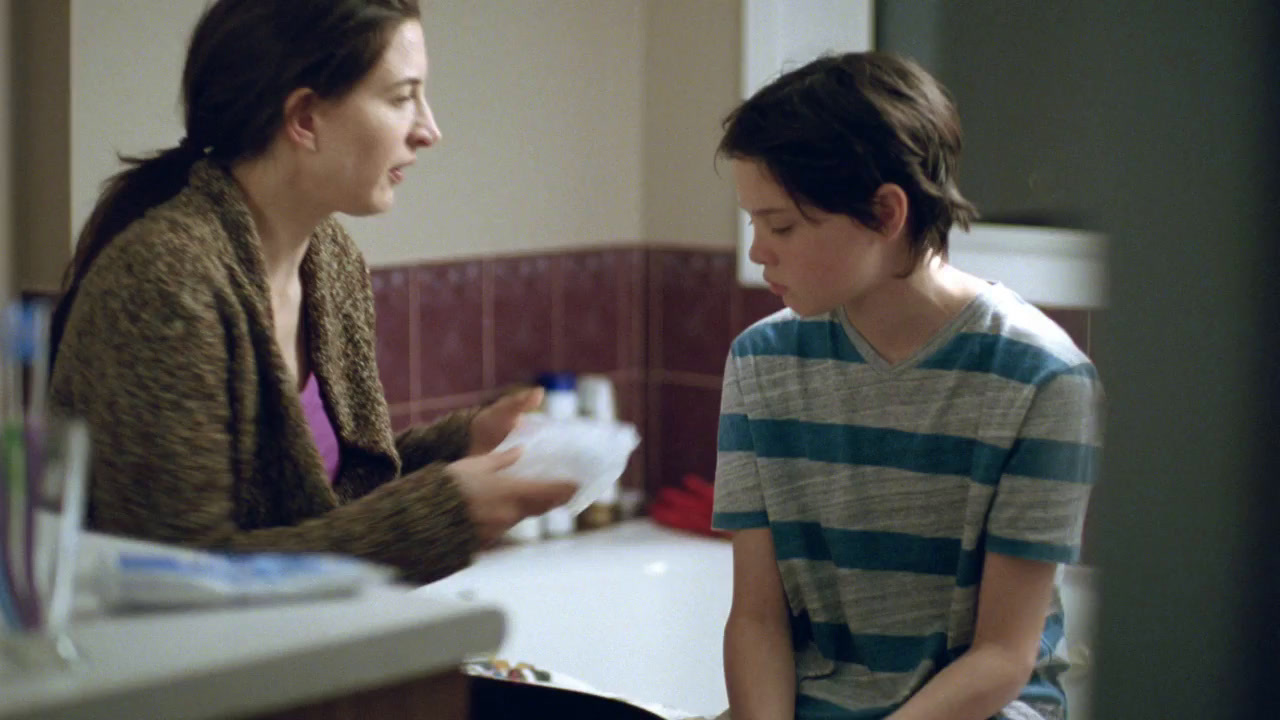 a woman standing next to a child in a bathroom