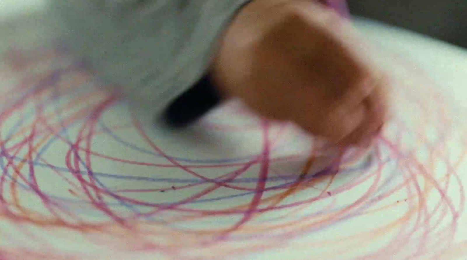 a close up of a person drawing on a piece of paper