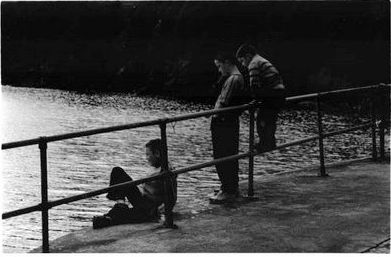 a couple of people that are sitting on a pier