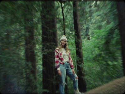 a woman standing in the middle of a forest