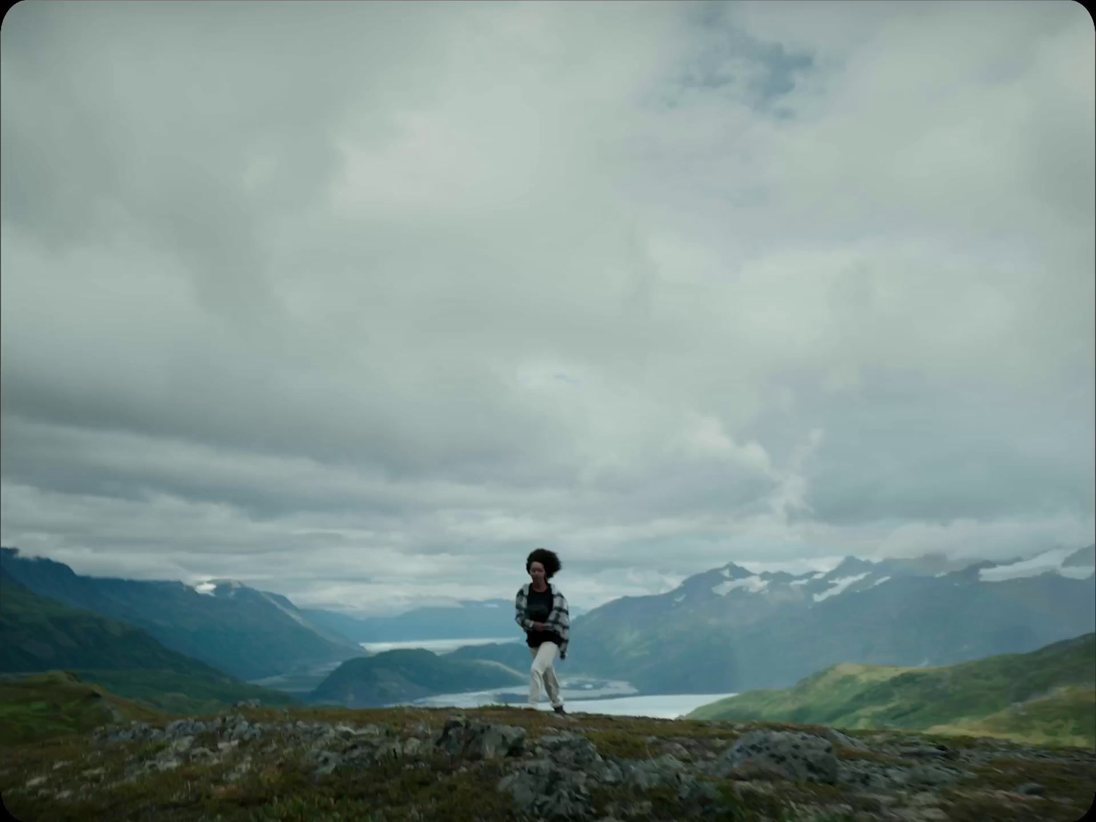 a man standing on top of a lush green hillside