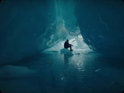 a man is sitting in an ice cave