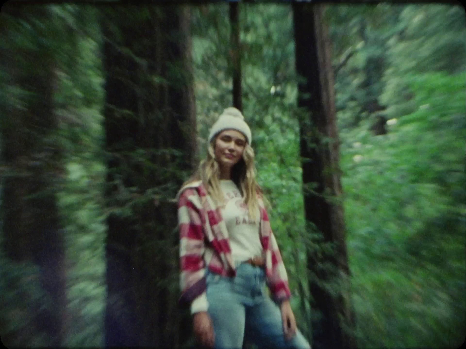 a woman standing in the middle of a forest