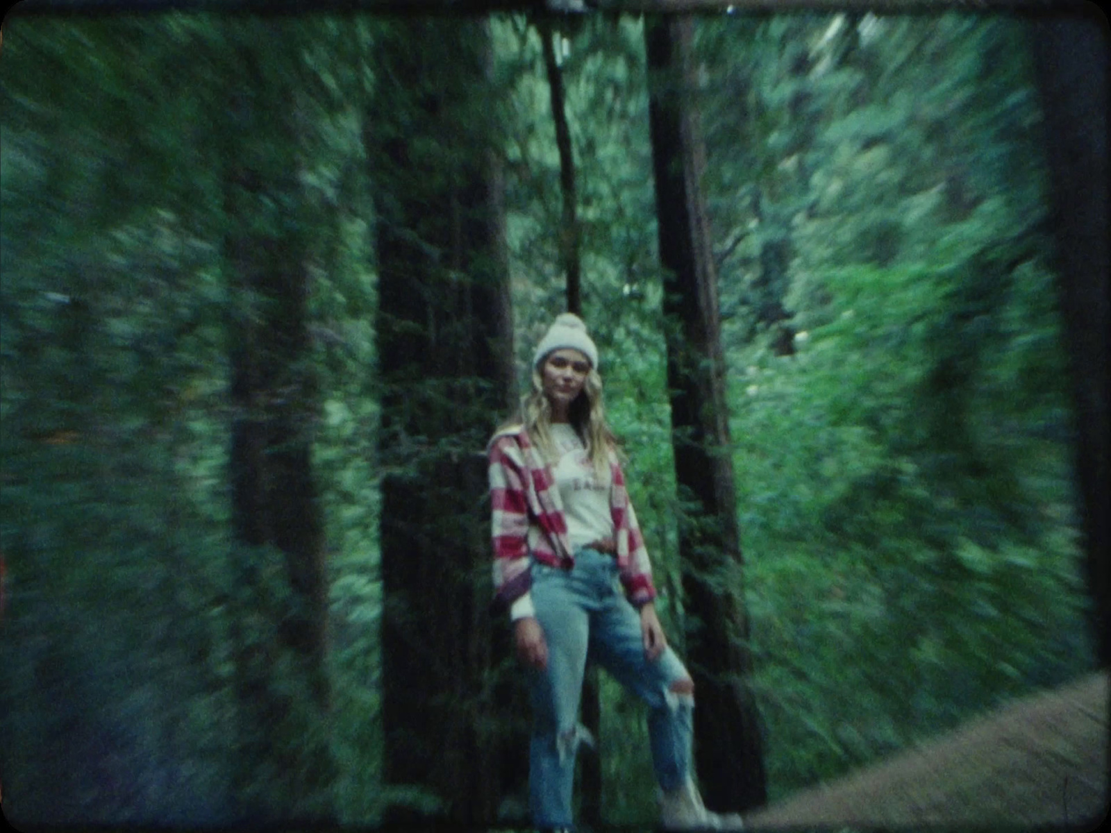 a woman standing in the middle of a forest