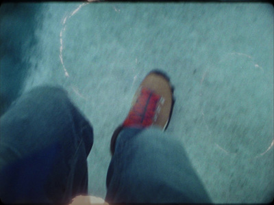 a person wearing red shoes standing on a sidewalk