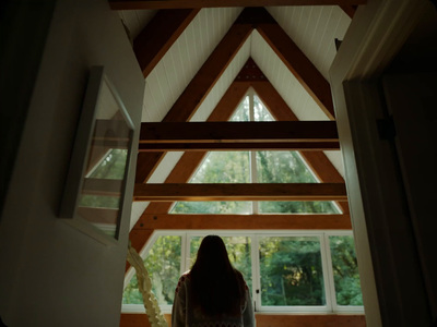 a woman standing in front of a window in a house