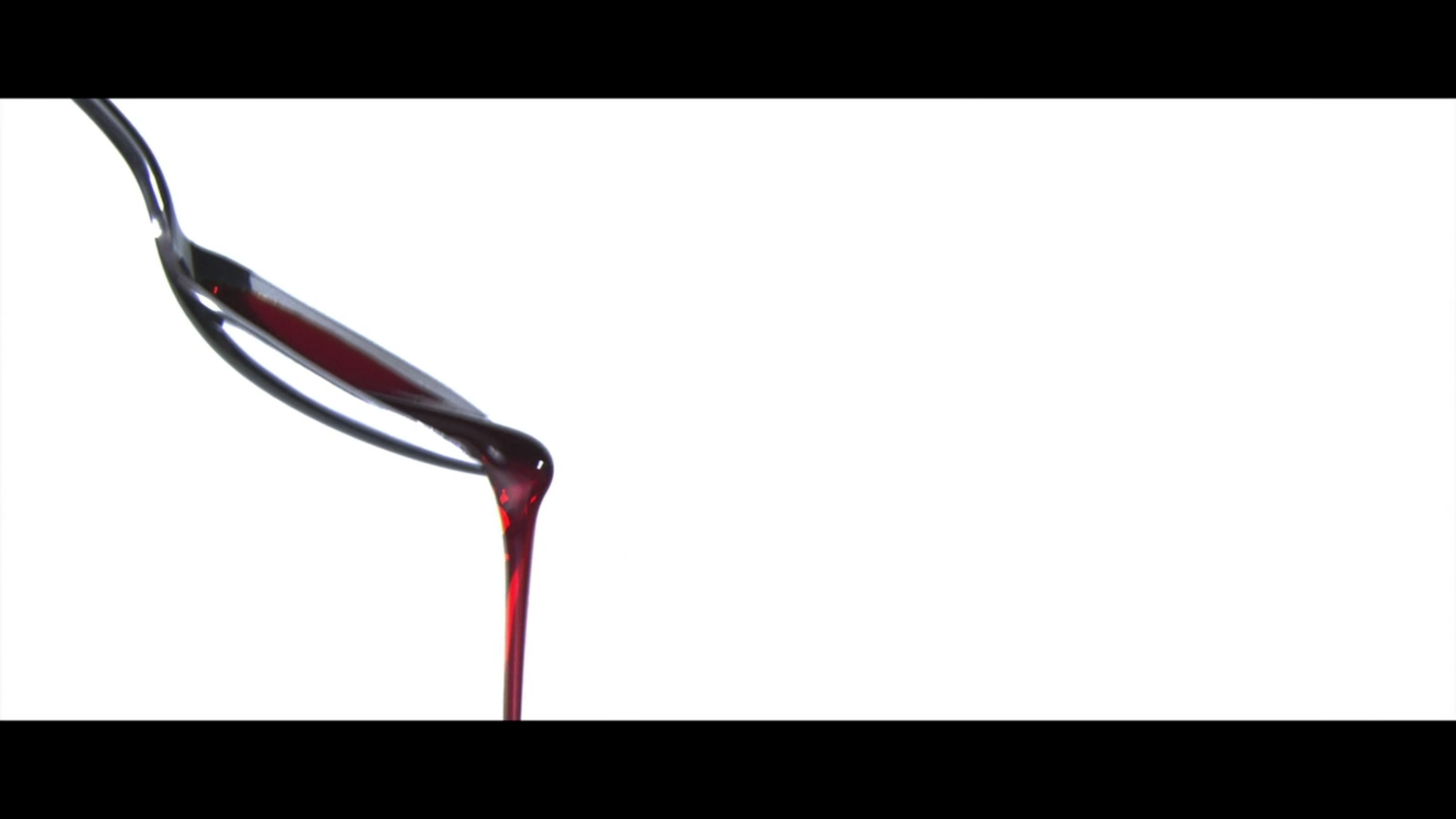 a red liquid pouring out of a spoon