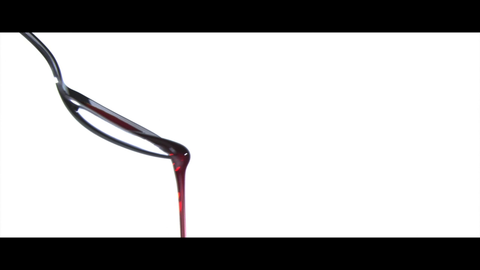 a red liquid pouring out of a wine glass