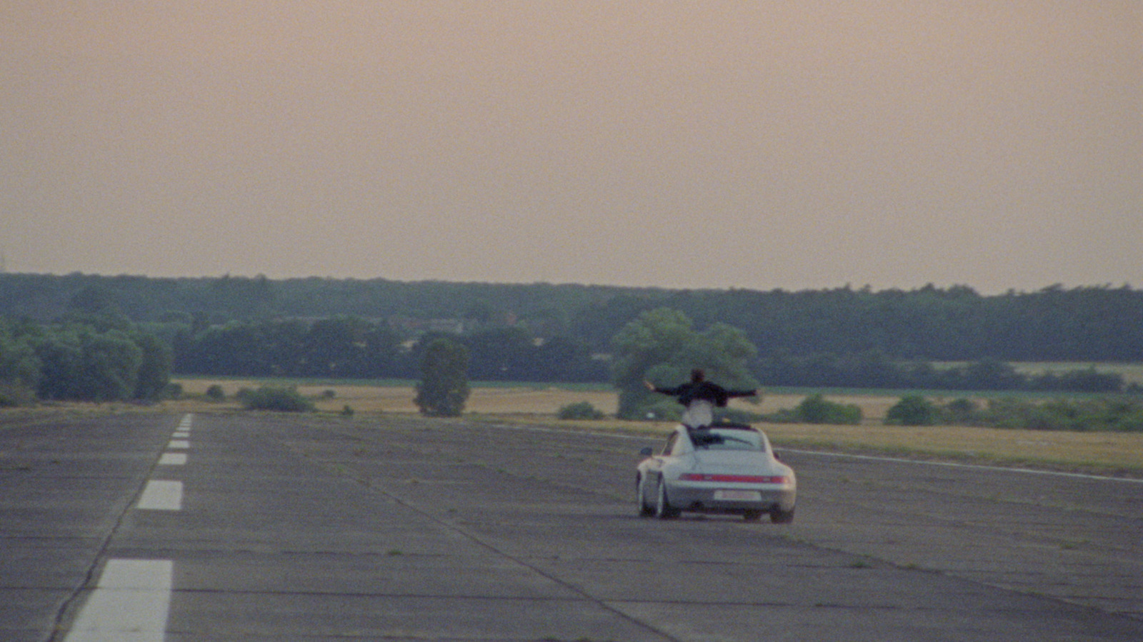 a car driving down a road with a person on top of it