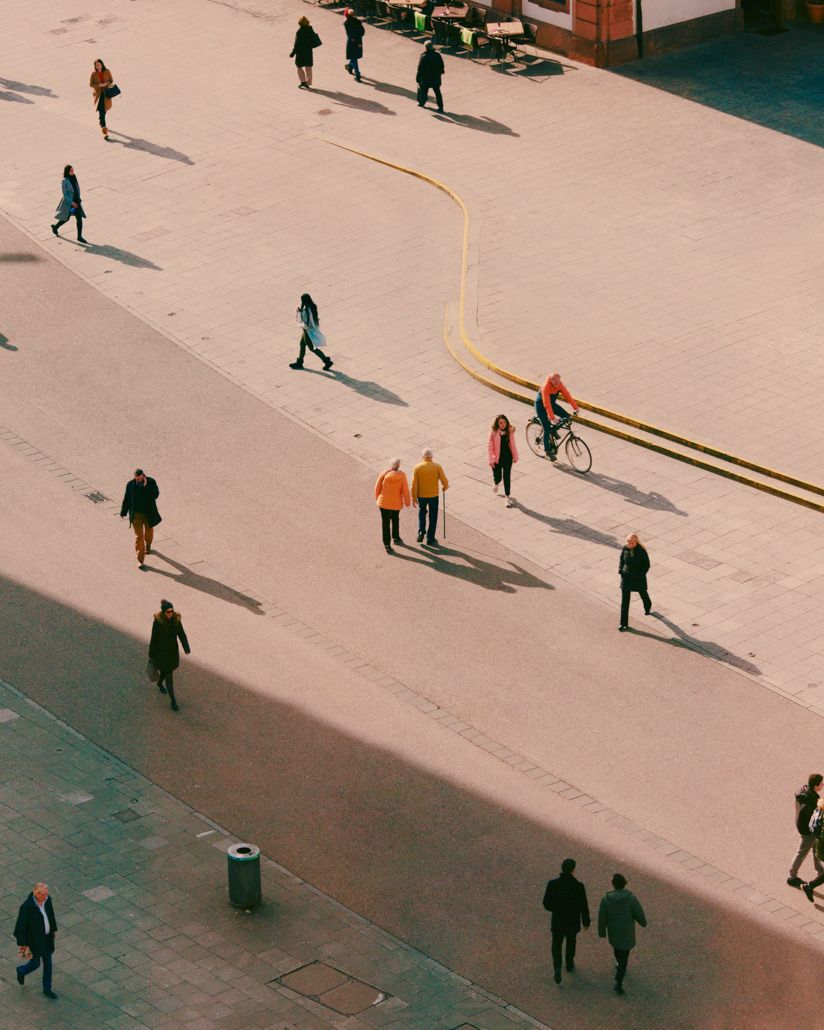 a group of people walking down a sidewalk