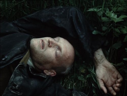 a man laying on the ground in the grass