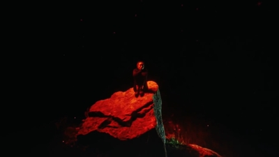 a person sitting on top of a rock in the dark