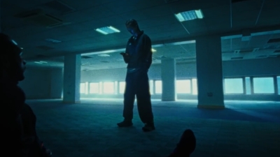 a man standing in a dark room looking at his cell phone