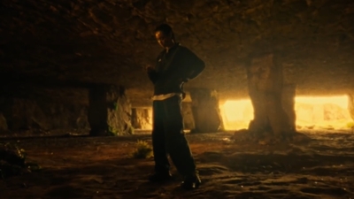 a man standing in a cave with his arms crossed