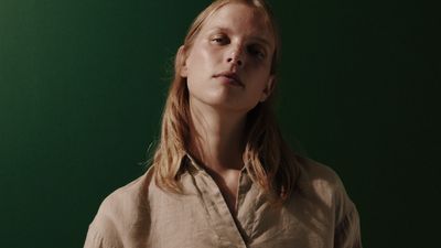 a woman standing in front of a green background