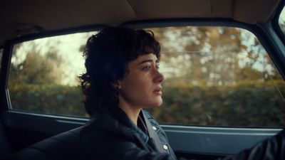 a woman sitting in a car with her head out the window