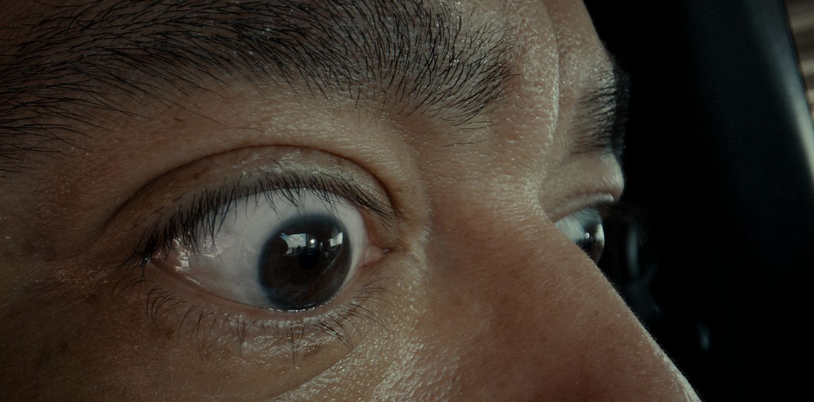 a close up of a person's eye with a cell phone in the background