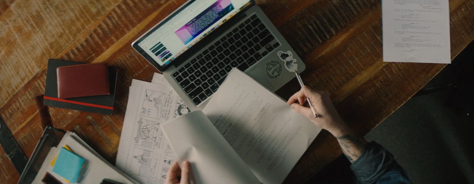 a person sitting at a table with a laptop and papers