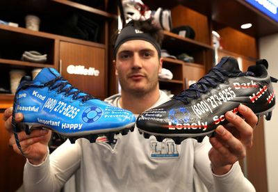 a man holding two soccer cleats in his hands
